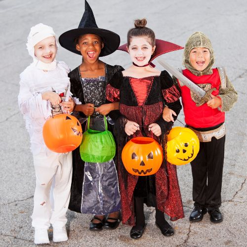 four children in Halloween costumes