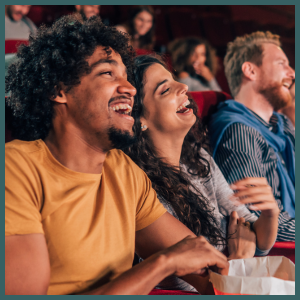 Laughing diverse movie theater crowd.