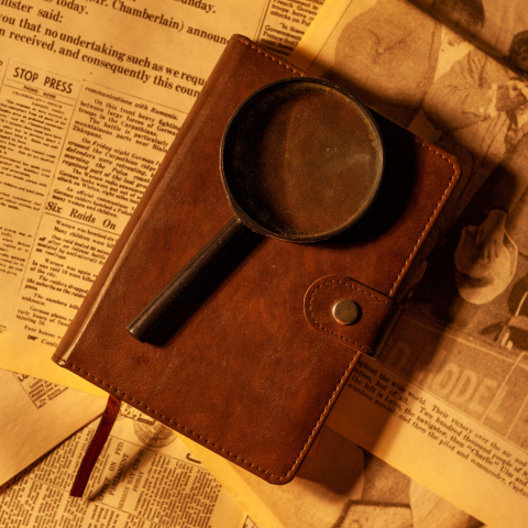 Magnifying glass on top of an antique notebook. 