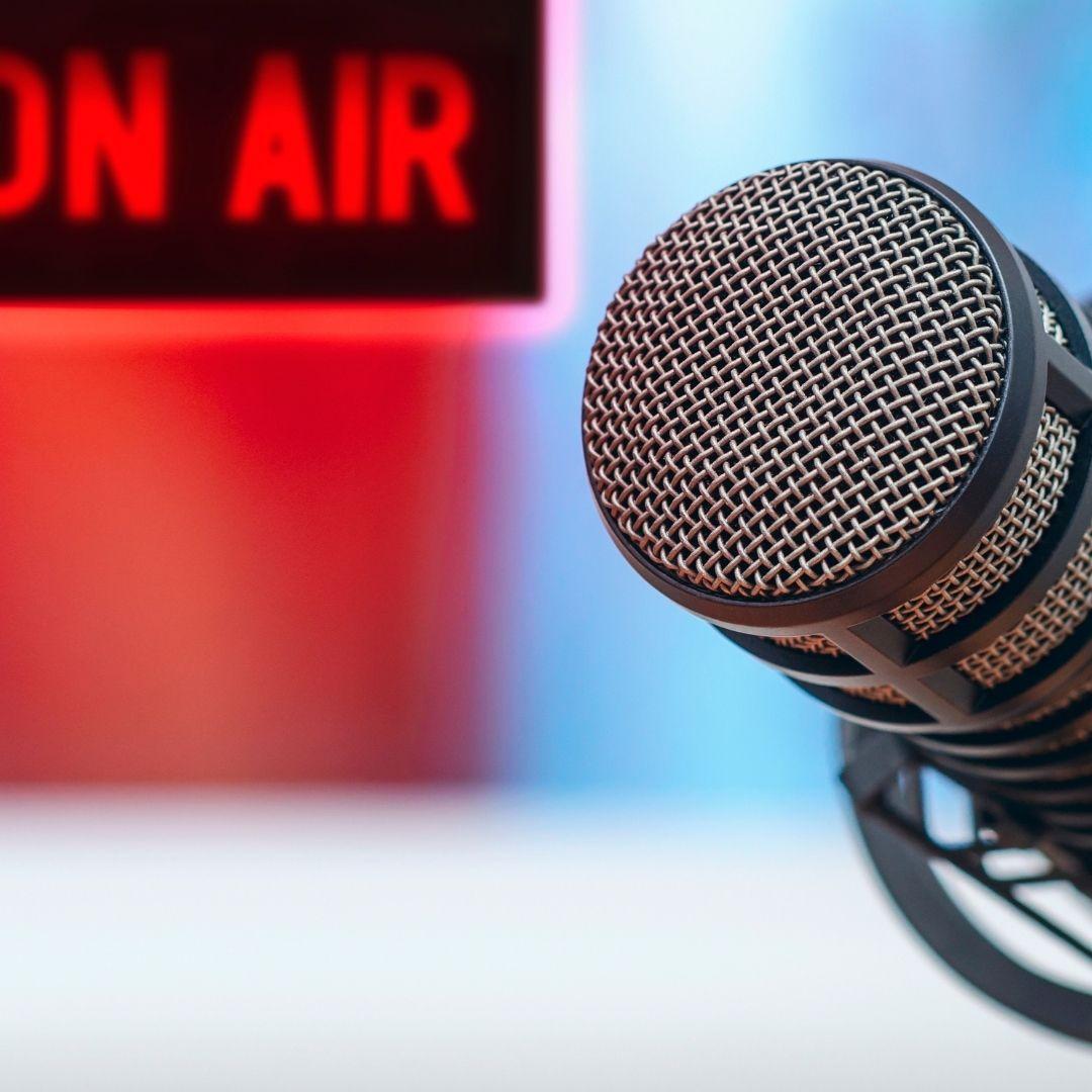 tabletop microphone with "on air" sign in background