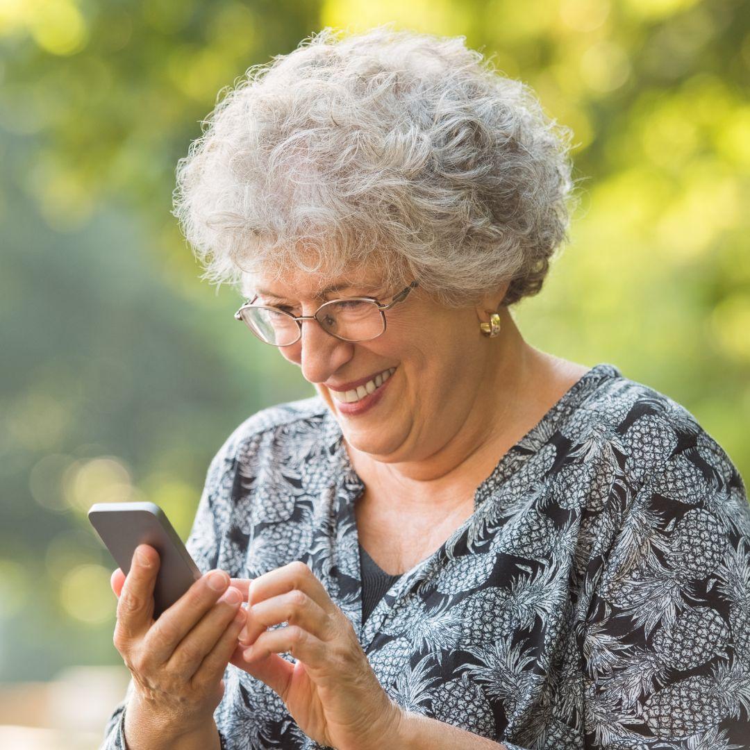 senior woman looks at smart phone