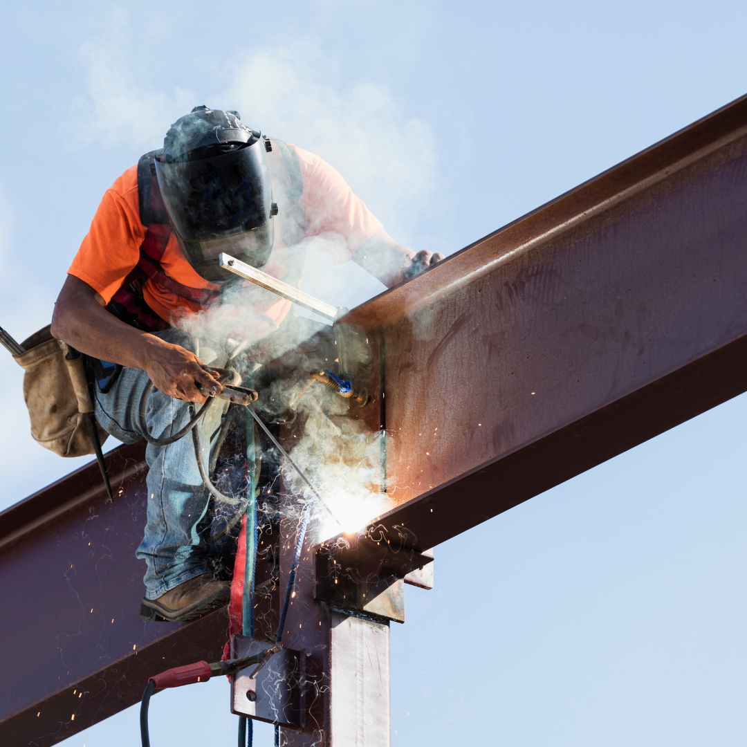 Person ironworking on a large red beam