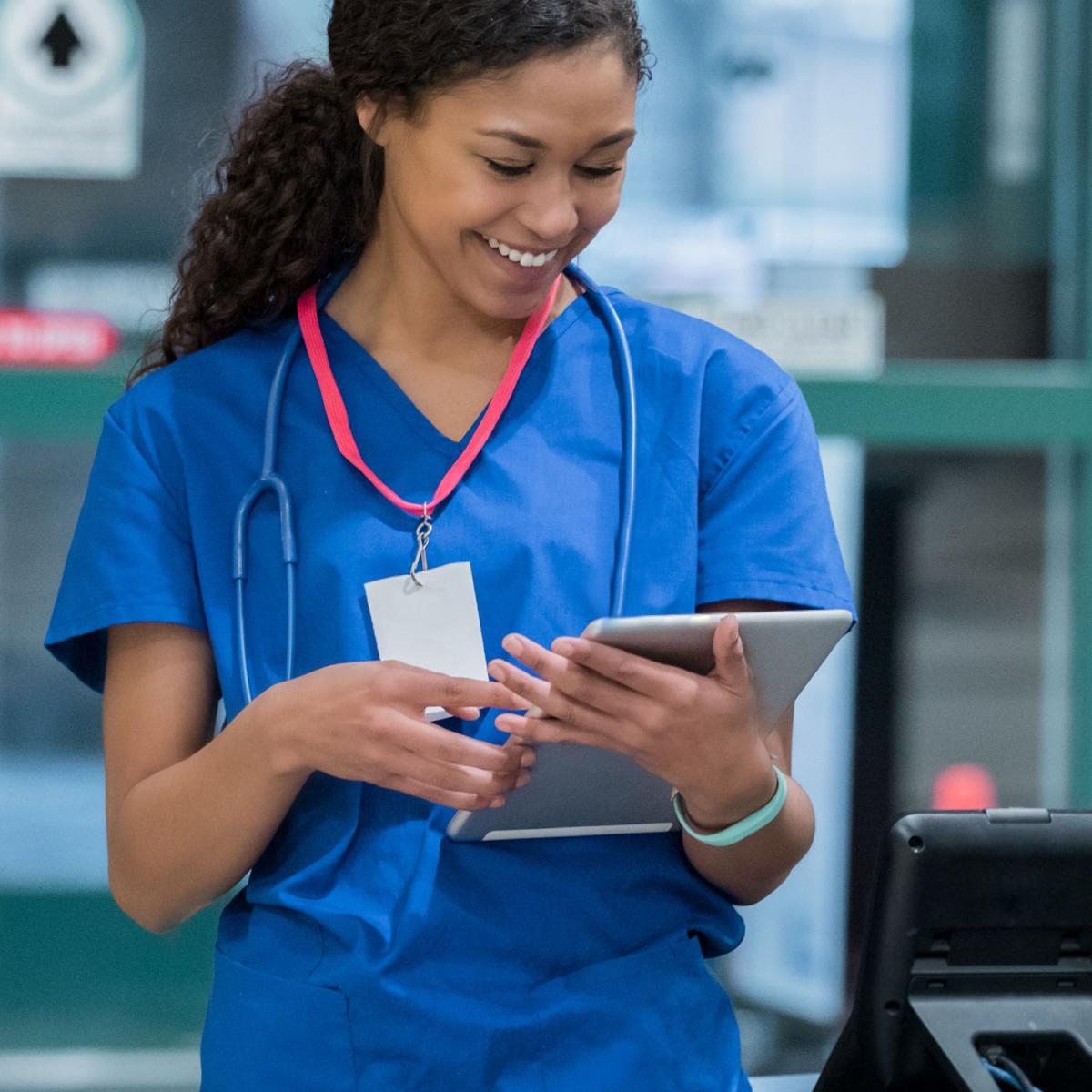 young adult in scrubs holds patient chart