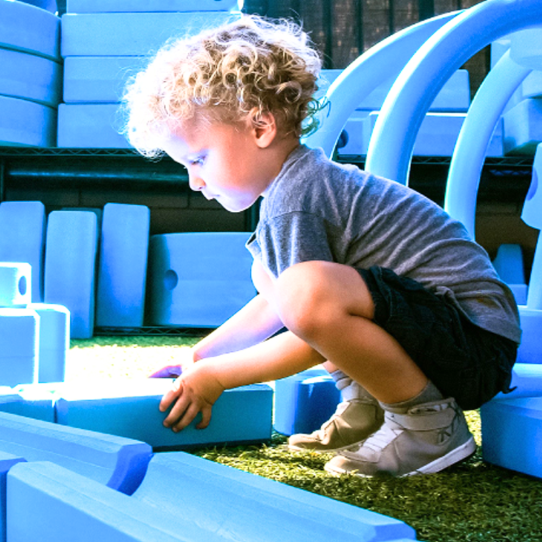 little boy playing with oversized foam blocks